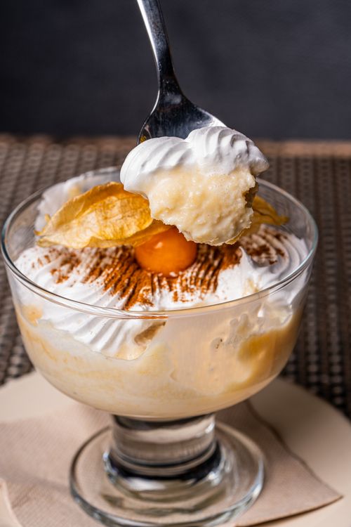 Free Indulge in this creamy dessert topped with whipped cream and garnished with fruit. Perfect for sweet lovers. Stock Photo