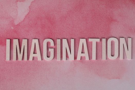 Inspiring Imagination text on pink watercolor background, symbolizing creativity and innovation.