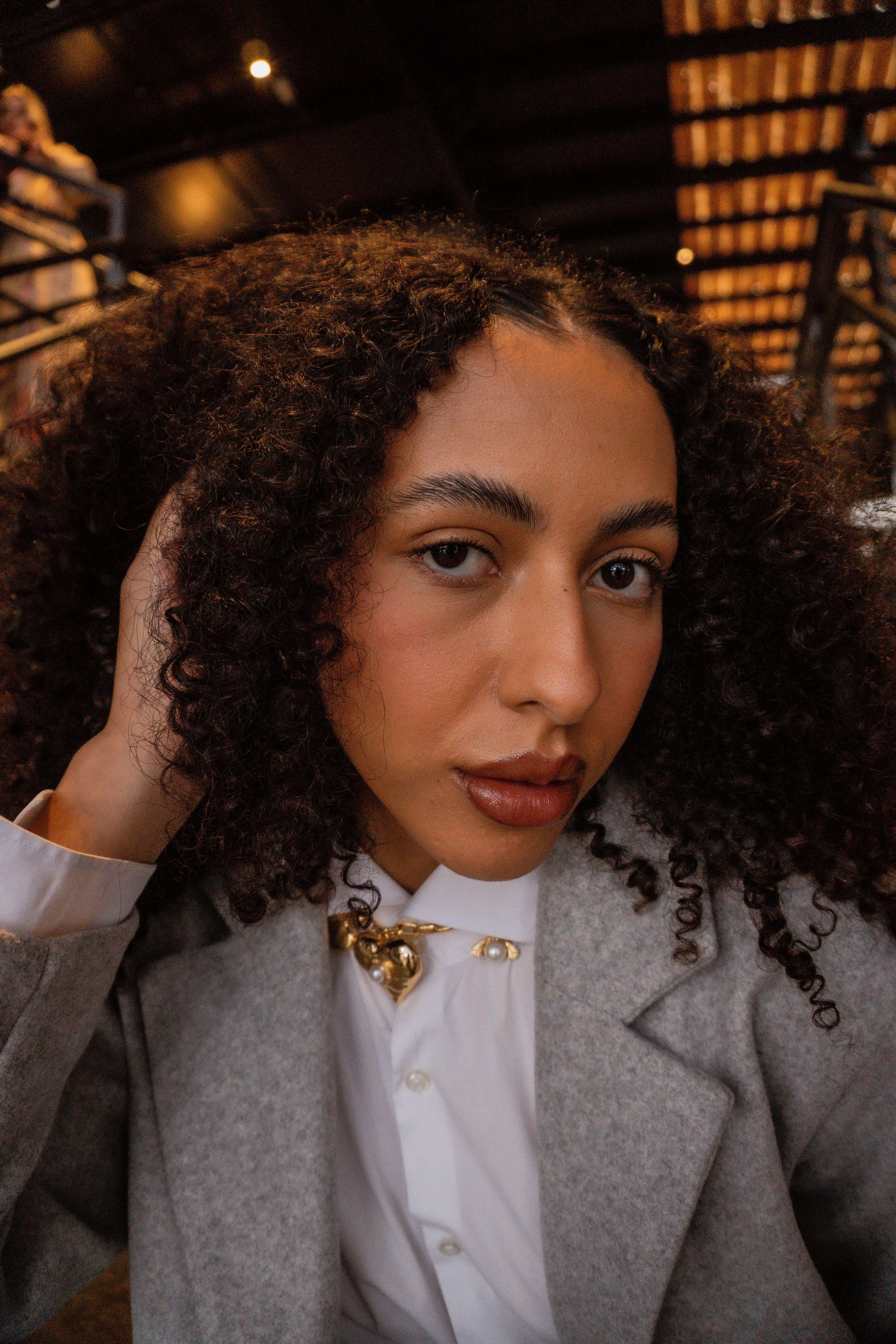 Portrait of a Stylish Woman with Curly Hair Indoors · Free Stock Photo