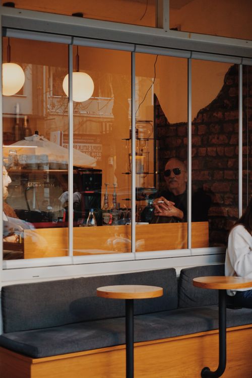 Free Cozy urban cafe scene through window with people enjoying warm ambiance. Stock Photo