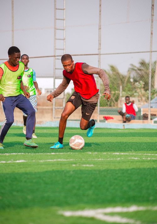 Free Players engaged in a vibrant soccer game on a sunny day, showcasing skill and teamwork. Stock Photo