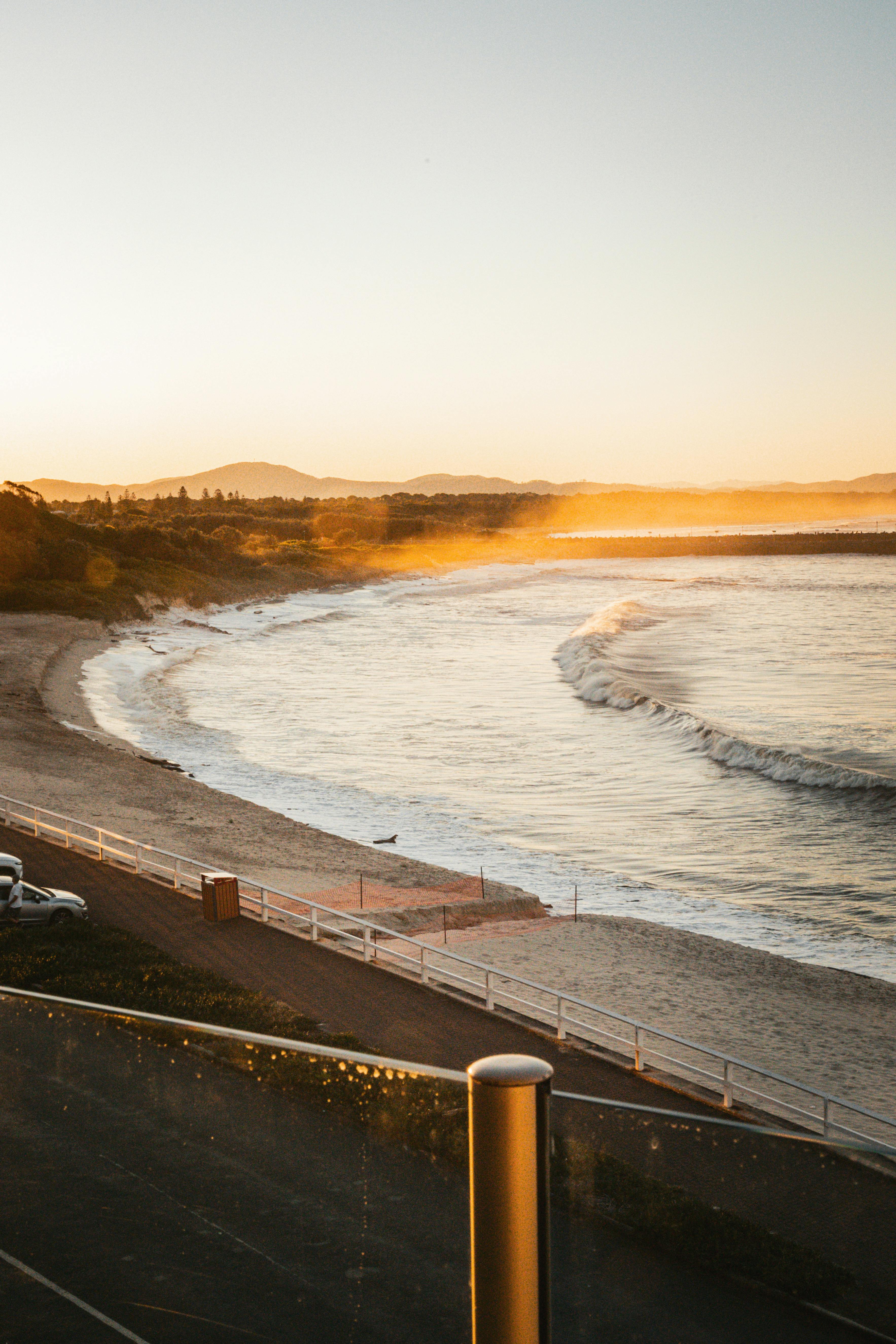 A calming view of a beach at sunset with gentle waves and warm light.