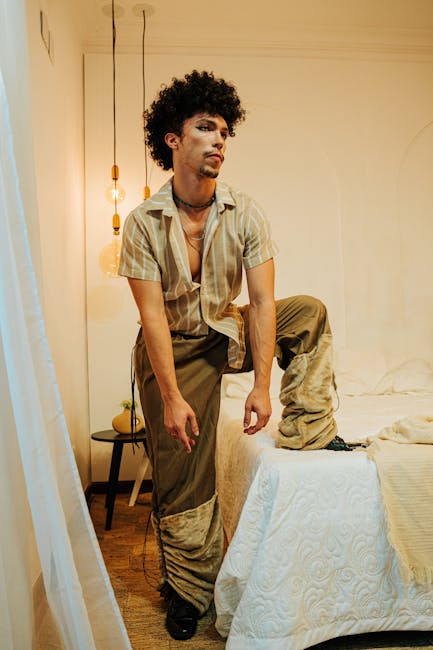 Man in vintage attire poses in a stylishly decorated room with warm lighting.