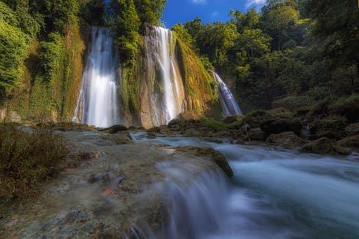Stunning waterfall surrounded by lush greenery in West Java, Indonesia, captured on a sunny day.