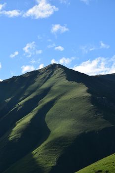 Stunning green mountain peak under a clear blue sky in Juta, Georgia.