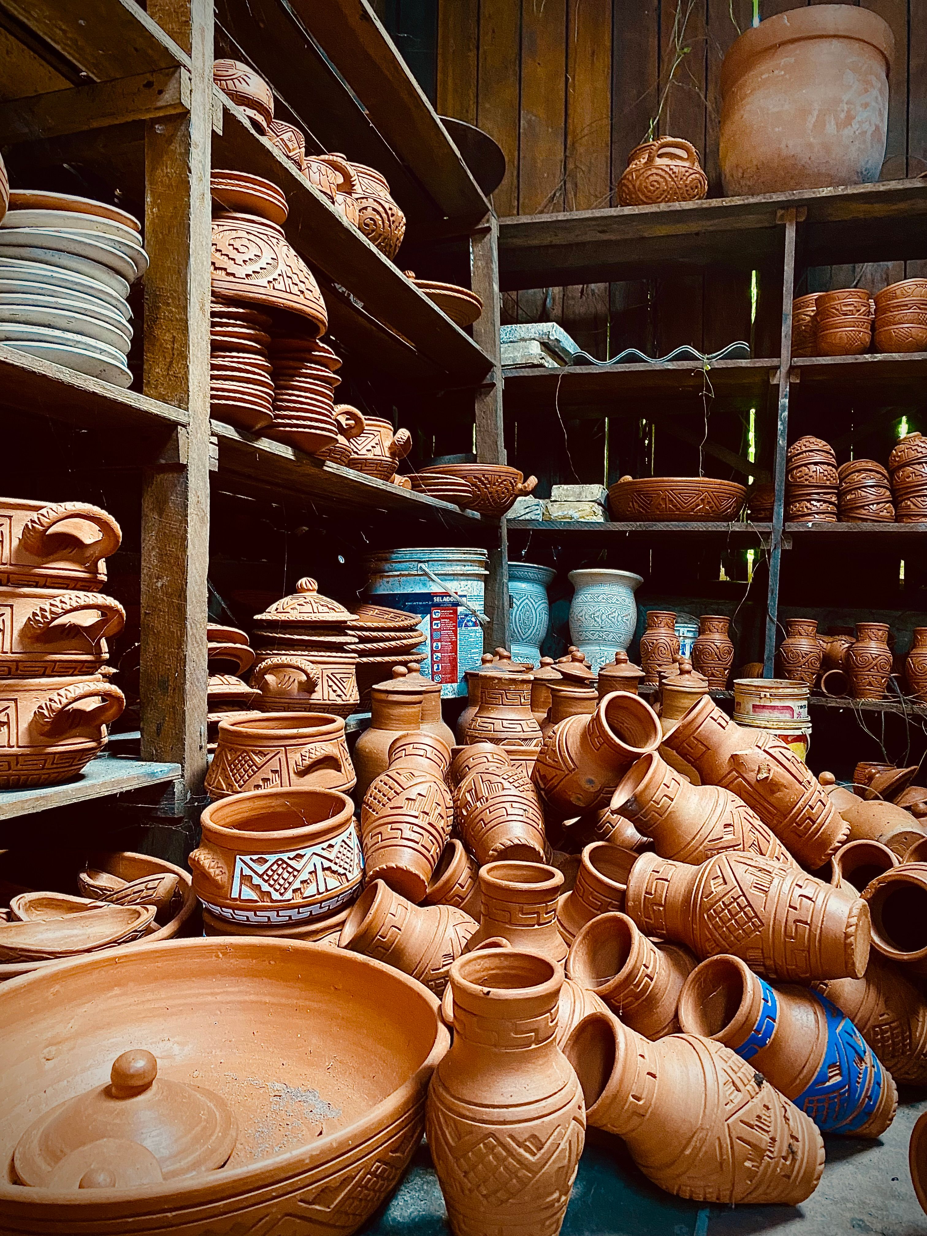 Fotomural Macetas y jarrones de terracota tradicionales en un entorno interior rústico, que muestran la artesanía.