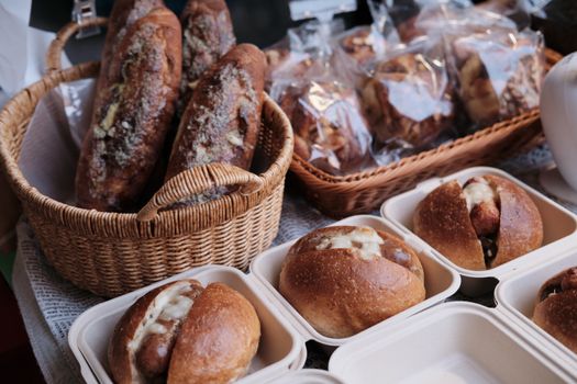 A variety of freshly baked artisan bread in baskets at a market stall.