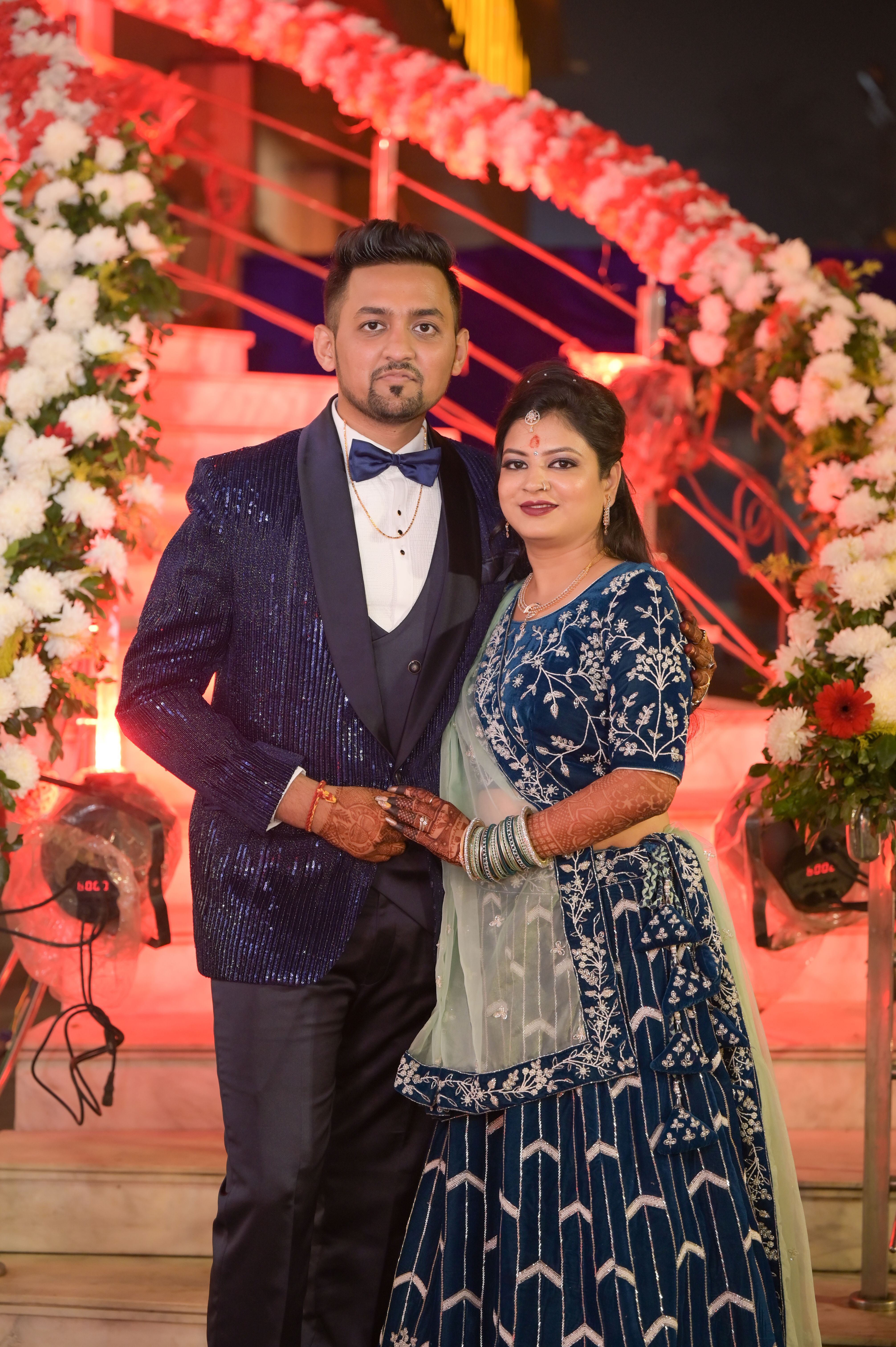 Stunning wedding couple in traditional attire posing at a beautifully decorated venue.