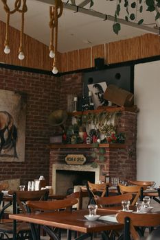 Warm and inviting cafe interior featuring a brick fireplace with rustic decor elements.