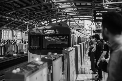 Free Black and white photo of a bustling Dhaka metro station with passengers waiting for the train. Stock Photo
