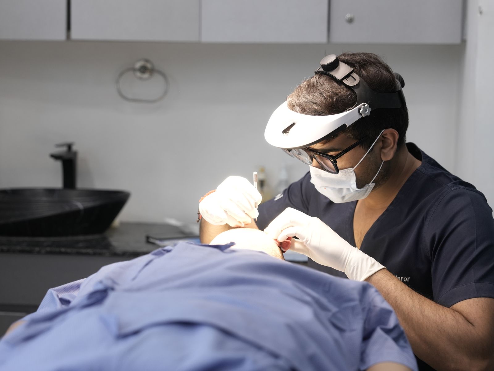 Dermatology clinician examining a patient in a modern clinic