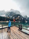 Photo of People Standing on a Lake Boardwalk