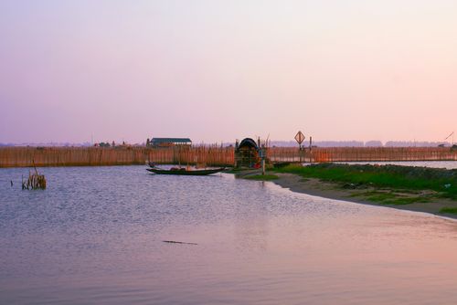 Free Serene fishing boats at sunset in Thành phố Huế, Vietnam, against a peaceful water landscape. Stock Photo