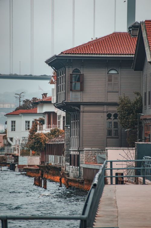 Free Charming waterfront houses in Istanbul with historical architecture and a bridge in the background. Stock Photo