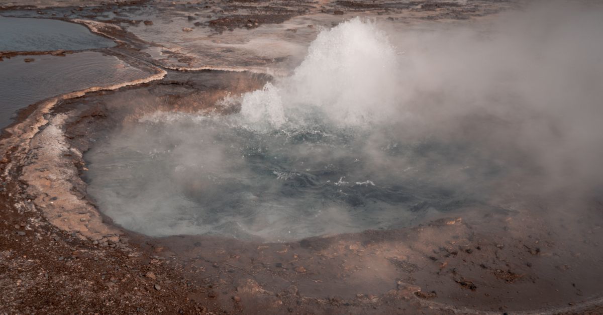 An active geyser erupting in the Icelandic landscape, captured in vivid detail.