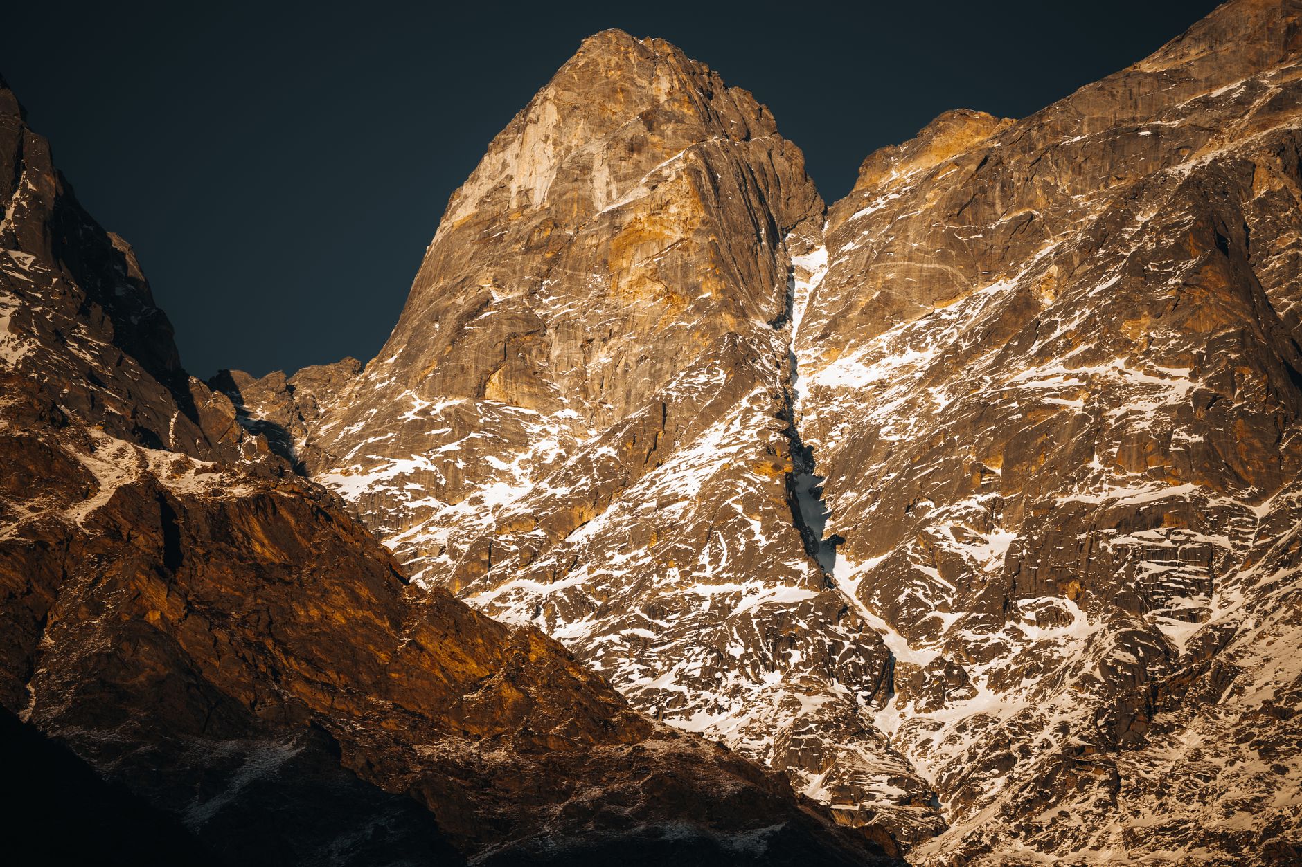 Stunning view of the Himalayan peaks during sunset, showcasing snow-covered rocky terrain.
