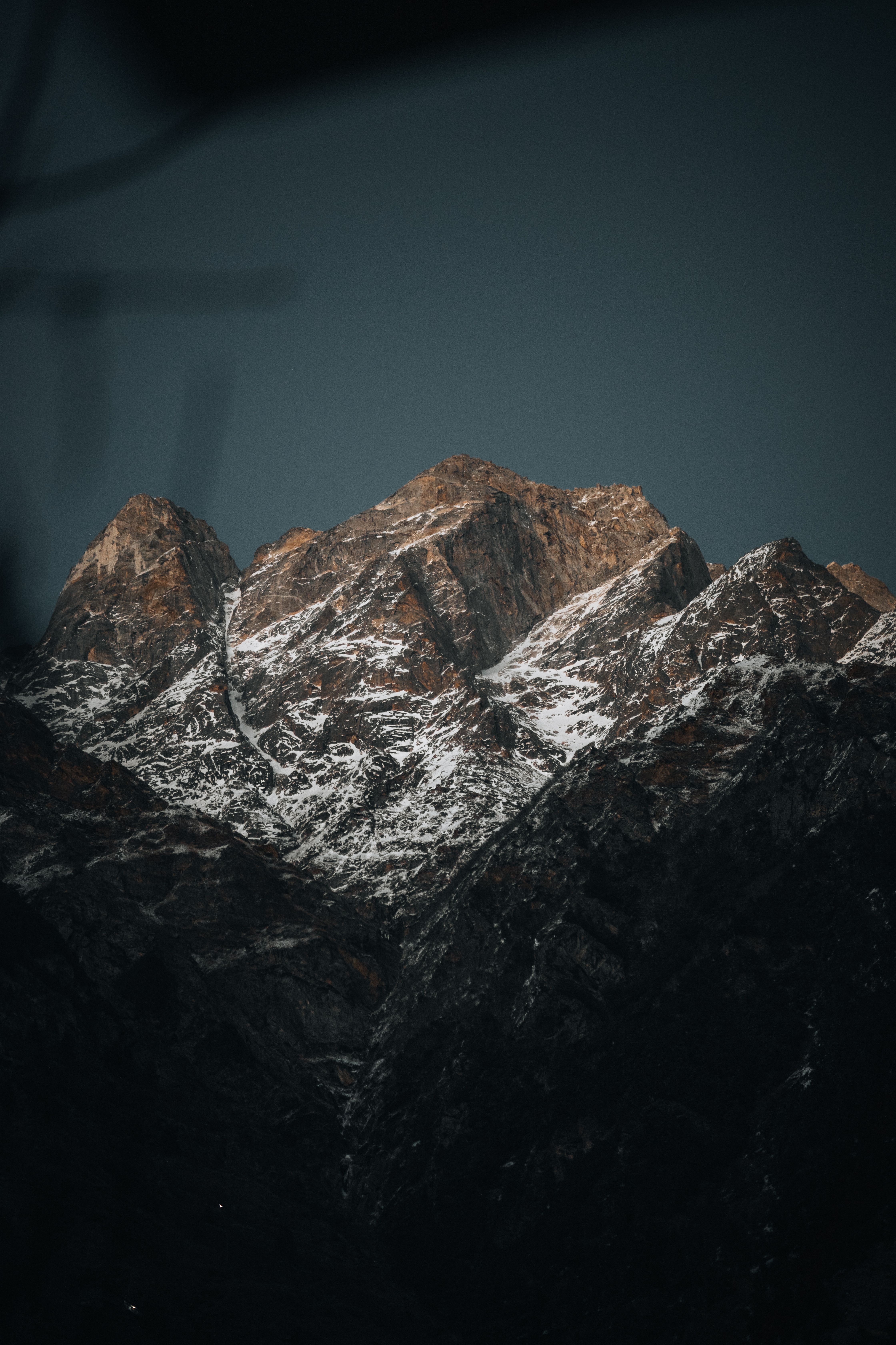 Captivating view of snow-capped Himalayan peaks under a twilight sky, showcasing natural beauty.