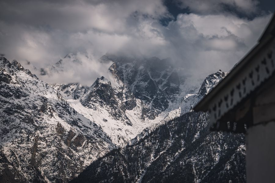 A stunning view of snow-covered Himalayan peaks shrouded in clouds.
