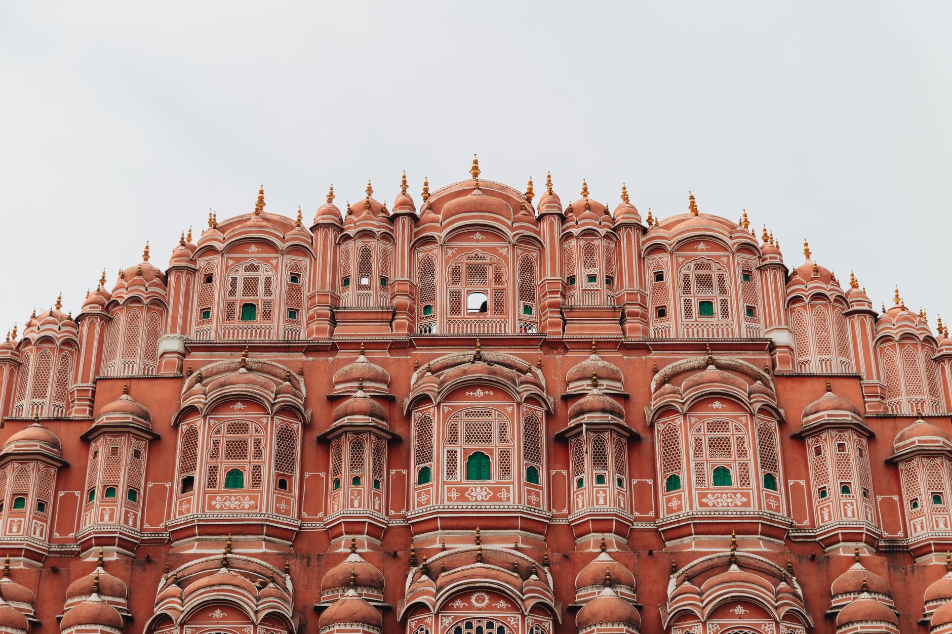 Hawa Mahal's pink sandstone facade above the traffic of Badi Chaupar in Jaipur