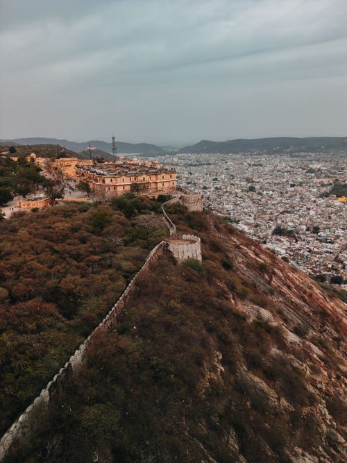 Free Aerial view of Amer Fort, a historic site in Jaipur, India, surrounded by hills and architecture. Stock Photo