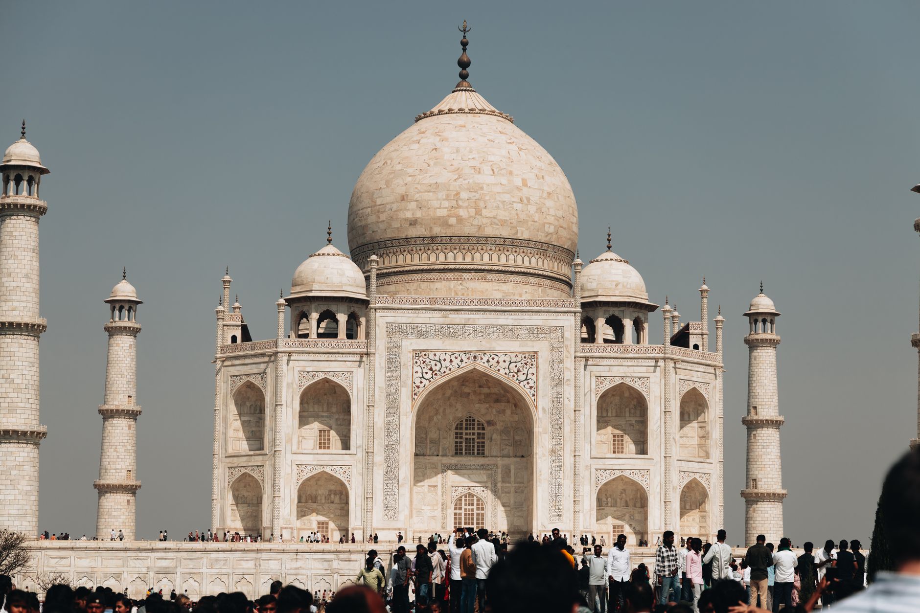 Agra tourist examining Taj Mahal entrance details beside a phone and printed travel documents