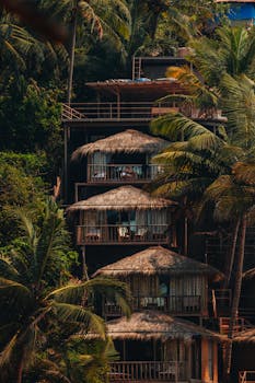 Peaceful tropical resort huts nestled in lush palm trees, capturing the essence of a serene getaway.