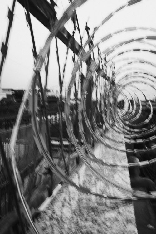 Free Artistic black and white blur of spiral barbed wire on a fence, capturing motion. Stock Photo