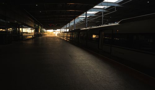 Free Train station platform with golden sunset light reflecting on the train and floor. Stock Photo