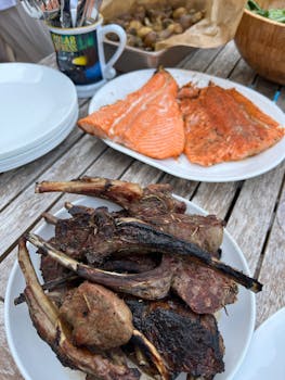 A vibrant outdoor meal featuring grilled meats and salmon, perfect for a summer gathering.