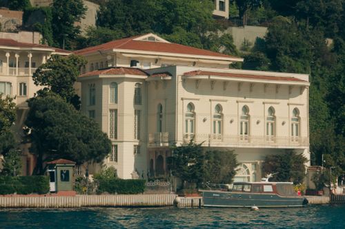 Free Stunning waterfront mansion with a boat on the Bosphorus, Istanbul, surrounded by lush greenery. Stock Photo