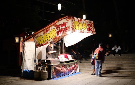 A vibrant street food stall at night selling crab sticks with customers visiting.