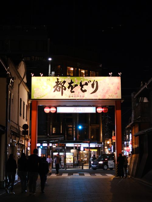 Free Bustling evening scene at a Japanese shopping district entrance, illuminated with lanterns. Stock Photo