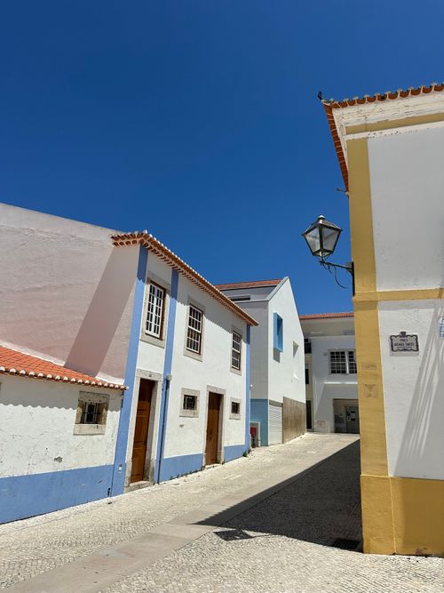 Free Bright blue sky over a picturesque street with colorful traditional Portuguese houses. Stock Photo