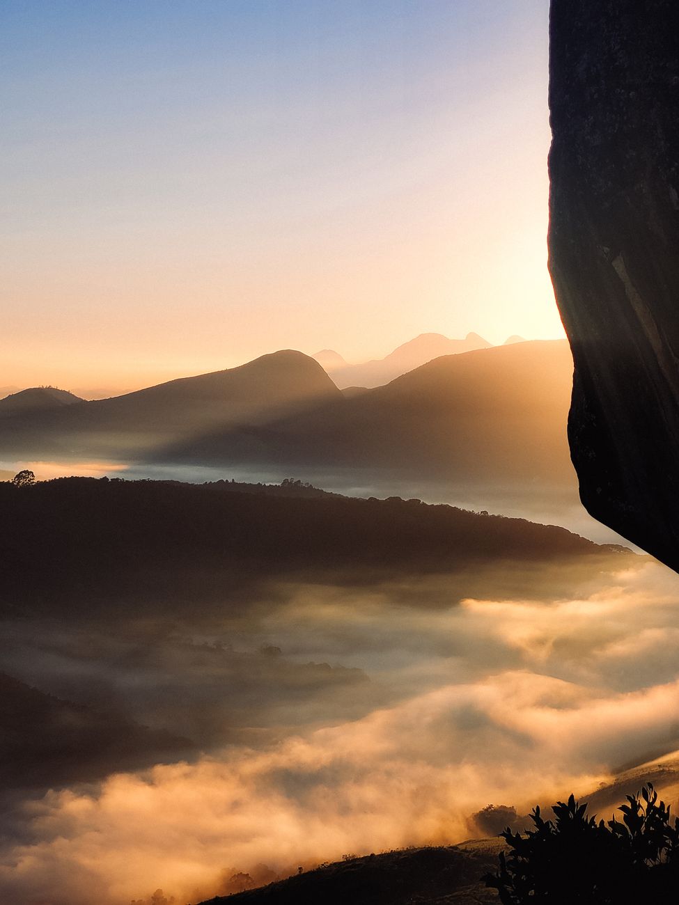 A beautiful sunrise over a mist-covered mountain range, creating a warm and serene atmosphere.