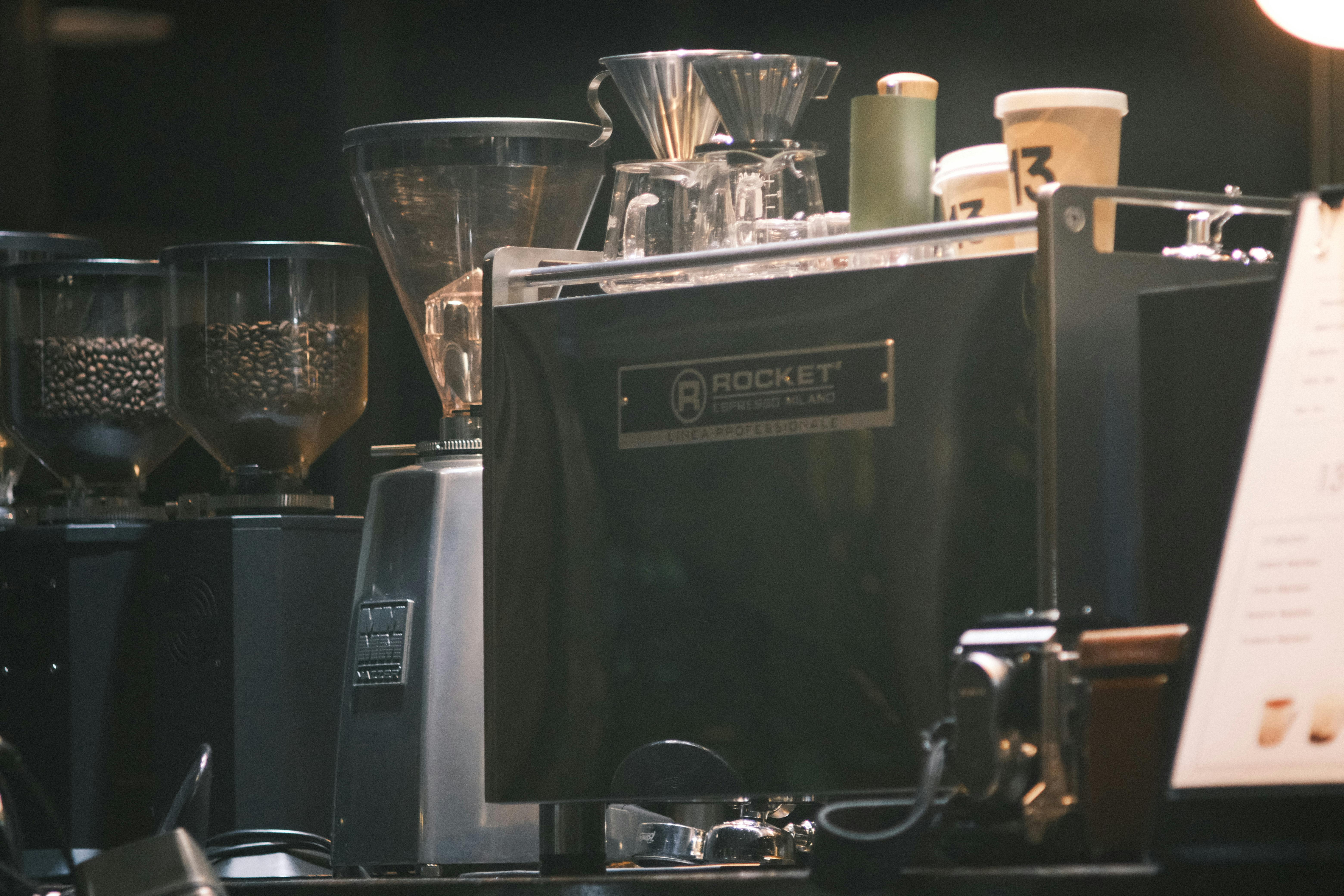 Close-up of an espresso machine in a cafe with coffee grinders and cups.