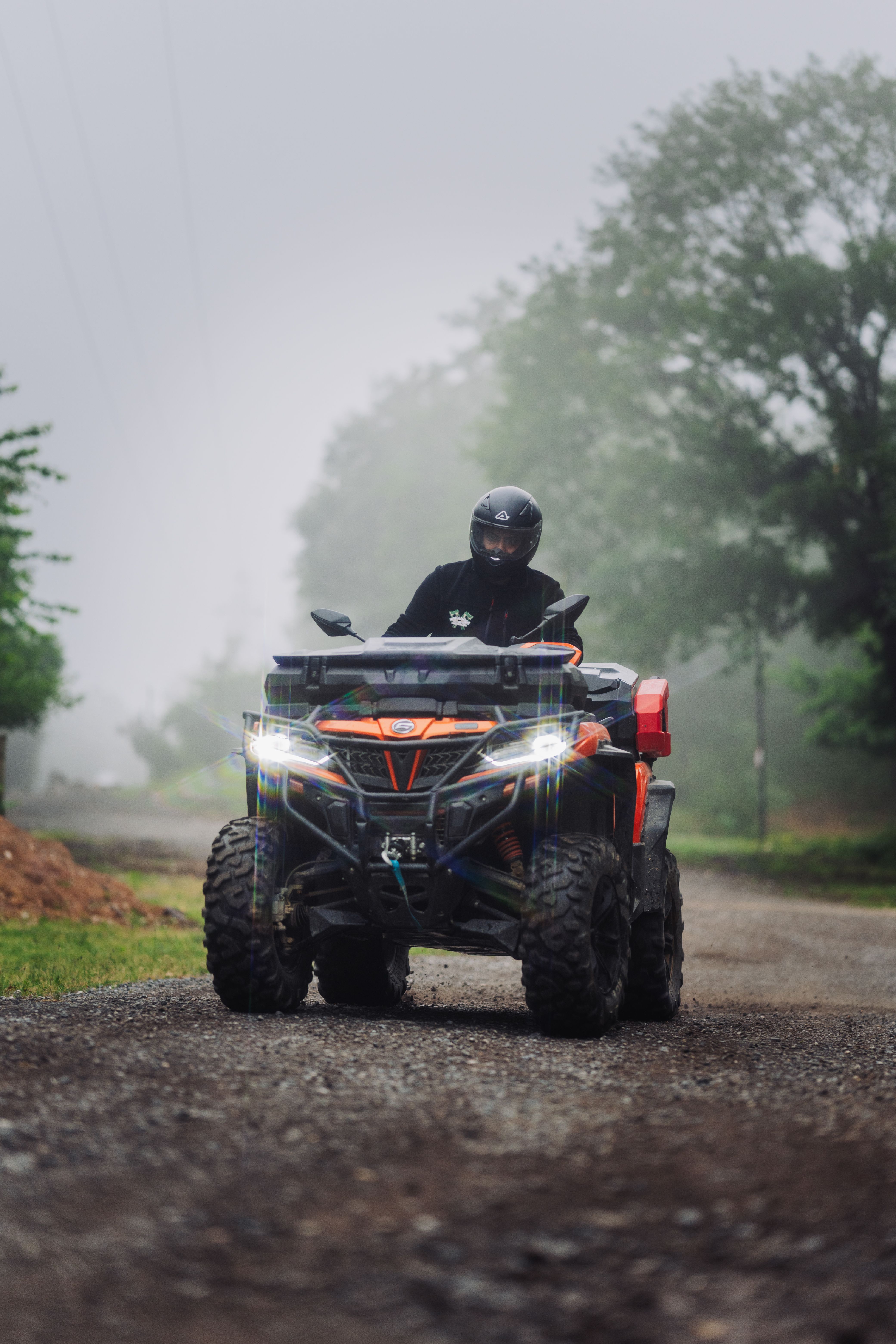 A person driving an ATV through a foggy forest trail, showcasing adventure and exploration.