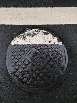 台湾台北潮湿井盖被道路线覆盖部分的特写镜头