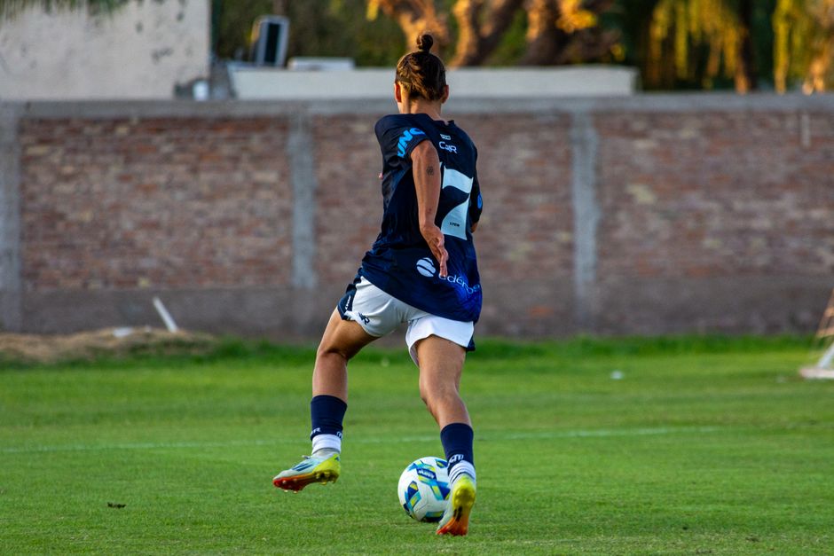 Soccer player in mid-motion on a grassy field, showcasing athletic skill and focus.