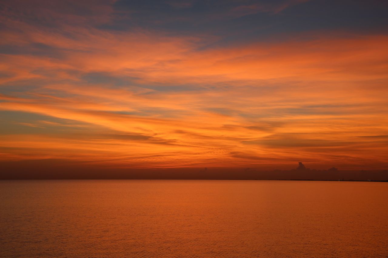 breathtaking orange sunset over a tranquil sea with vibrant sky and so