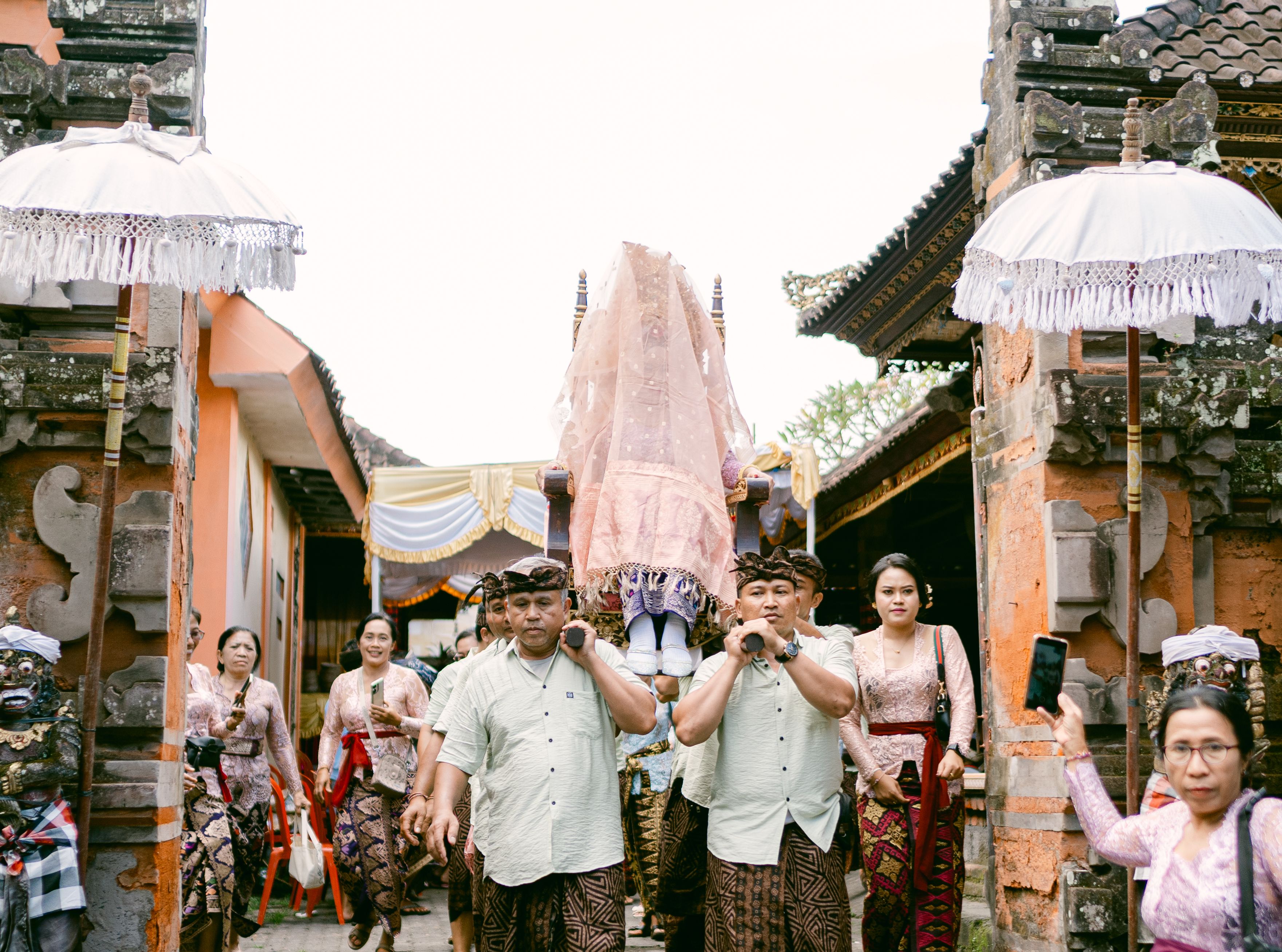 Cultural Balinese wedding procession with ornate attire and traditional elements.