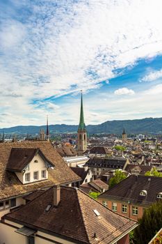 Aerial view of Zürich showcasing historic architecture and the iconic Fraumünster Church under a bright blue sky.