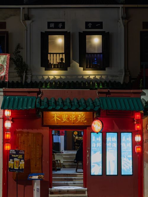 Free A vibrant street view of a restaurant in Singapore's Chinatown at night, with traditional architecture and red lanterns. Stock Photo