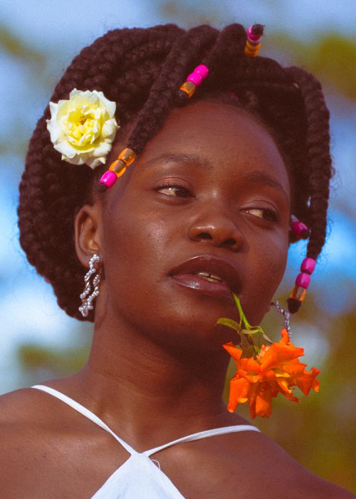 Free Elegant portrait of woman with braided hair and flowers, exuding vibrant summer vibes. Stock Photo