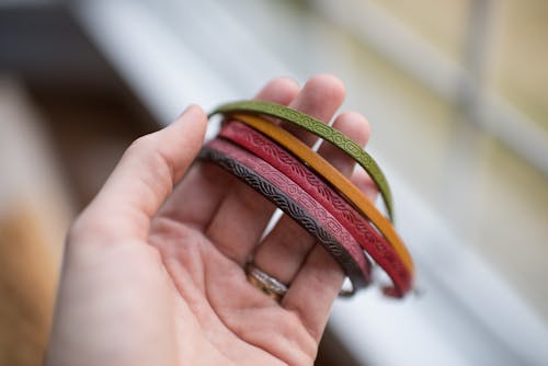 Nahaufnahme Der Menschlichen Hand, Die Mehrfarbige Armbänder Hält