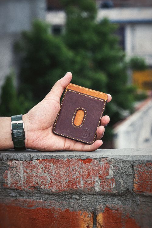 Free A hand holds a handmade leather wallet, showcasing everyday fashion style outdoors. Stock Photo