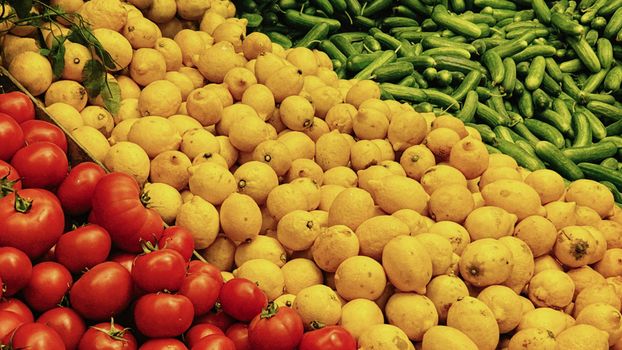 Vibrant market scene featuring fresh tomatoes, lemons, and cucumbers in an artistic arrangement.