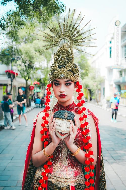 Free Vibrant photo of a cultural performer with an intricate costume and mask, set outdoors. Stock Photo