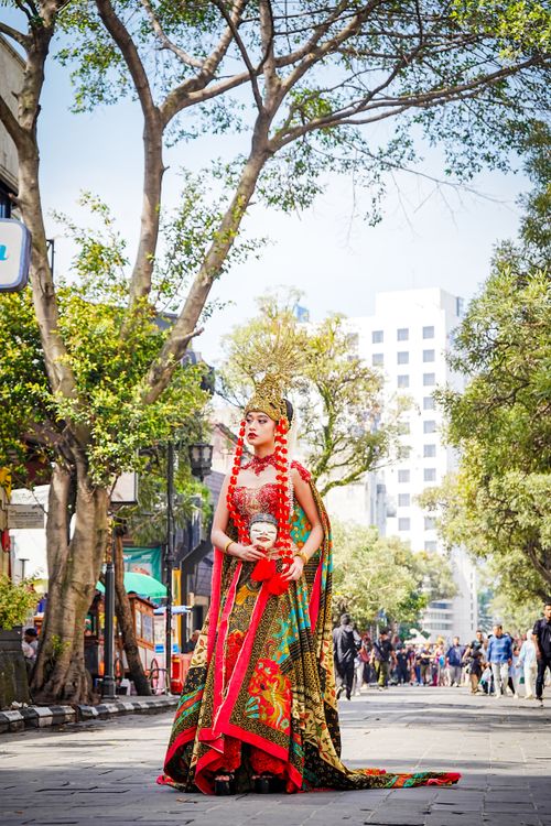 Free Woman in traditional attire parades outdoors, showcasing vibrant cultural fashion with city backdrop. Stock Photo