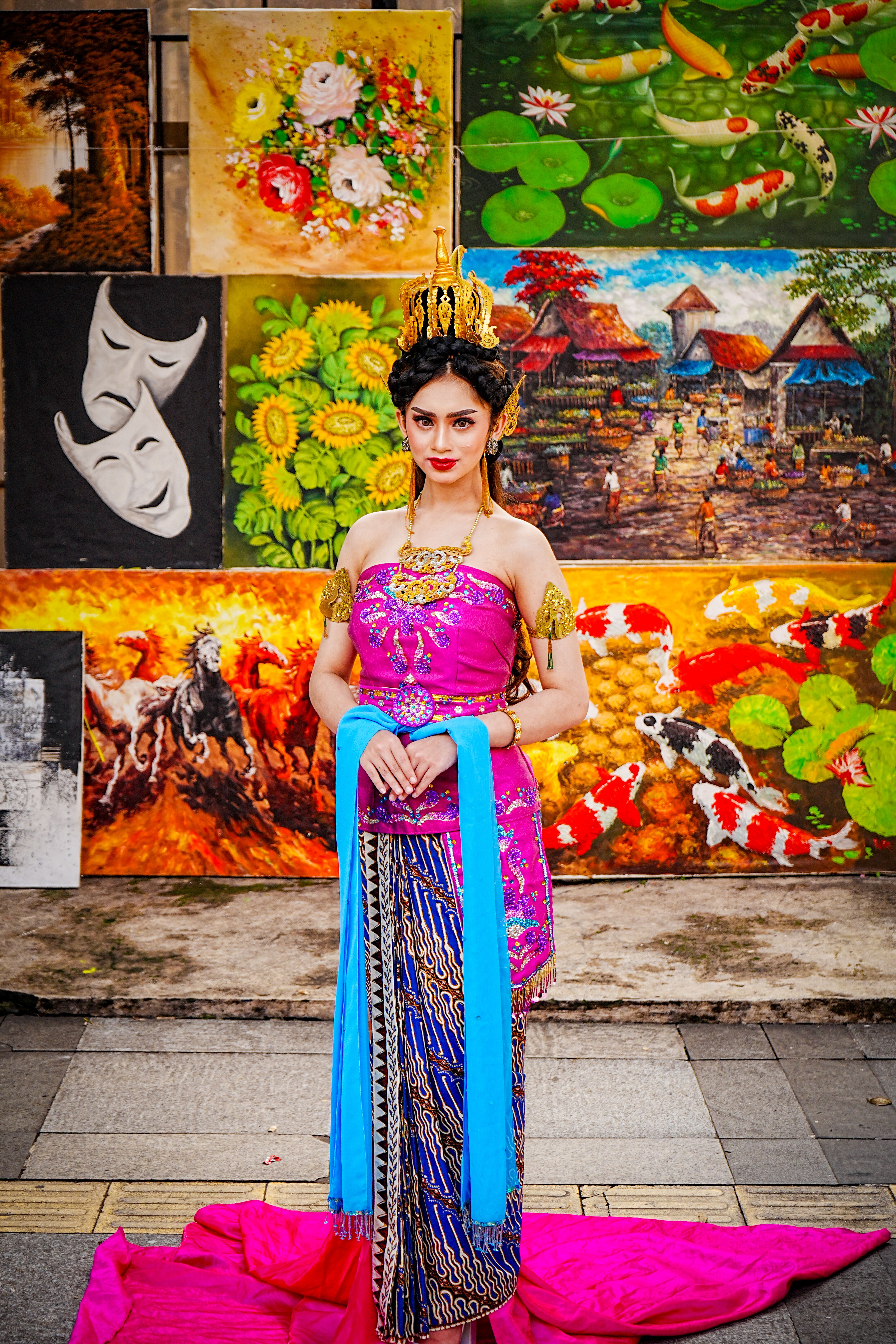 [ColoSach]-a-woman-in-vibrant-traditional-attire-poses-against-a-colorful-artistic-background.