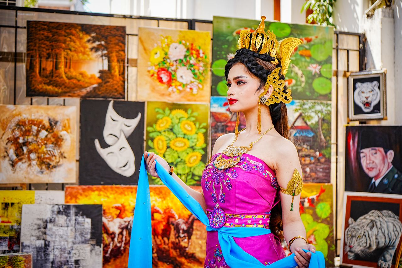elegant woman in traditional attire posing at an art gallery with vibr